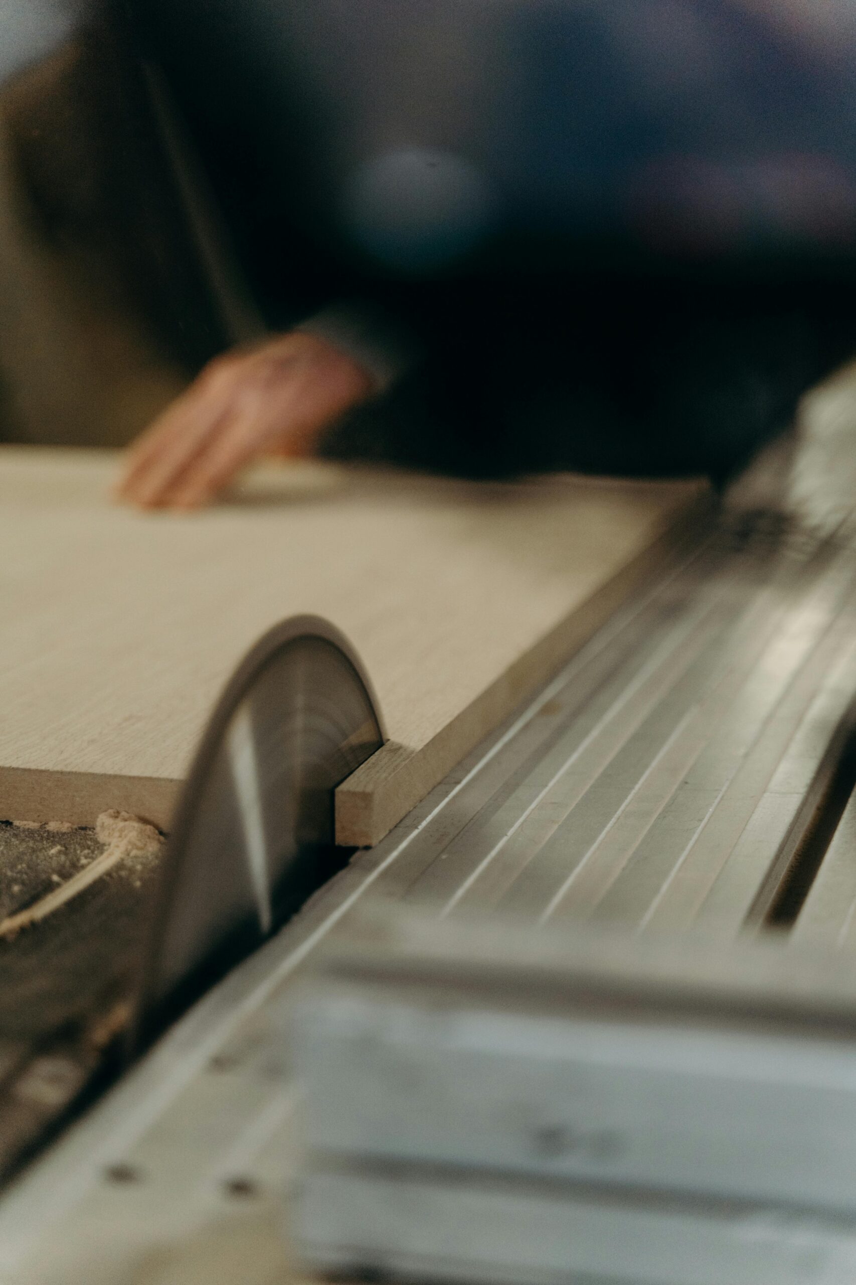 A carpenter uses a circular saw to cut wood smoothly in a workshop.